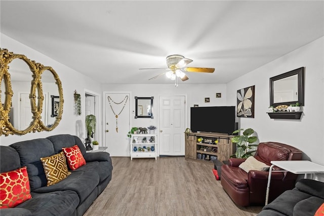 living area with a ceiling fan and wood finished floors