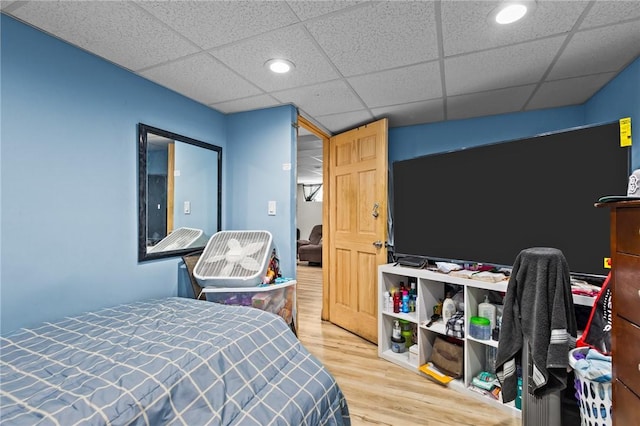 bedroom featuring recessed lighting, a paneled ceiling, and wood finished floors