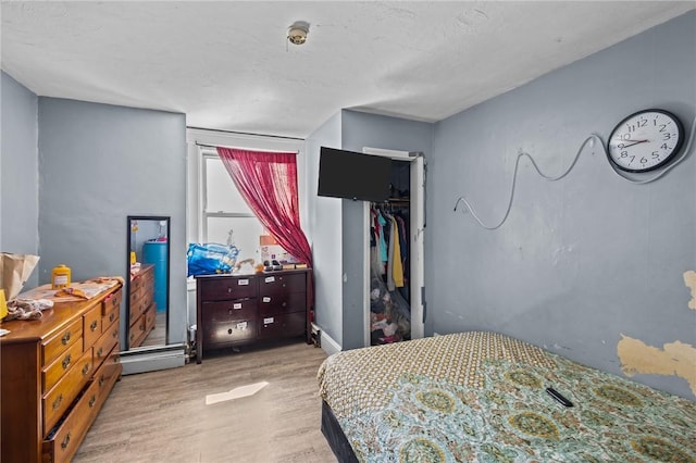 bedroom with wood finished floors and a closet