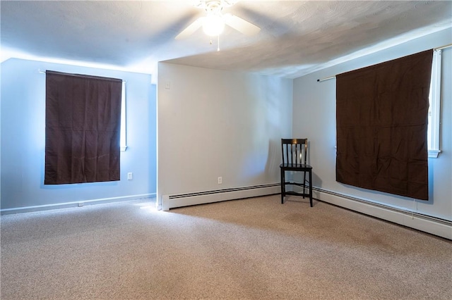 unfurnished room with carpet floors, baseboards, ceiling fan, and a baseboard heating unit