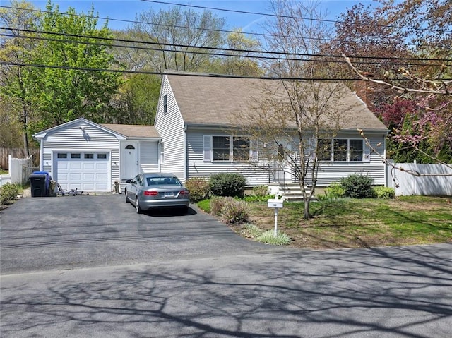 view of front of home featuring an attached garage, driveway, and a shingled roof