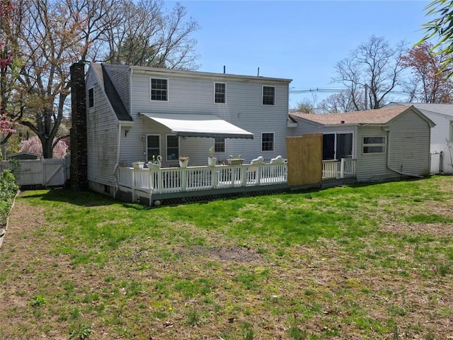back of property featuring a lawn, a wooden deck, a gate, and a chimney