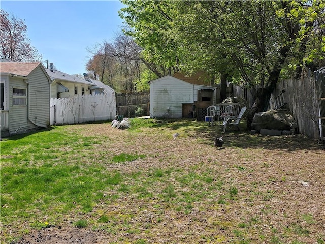 view of yard featuring a fenced backyard, an outbuilding, and a storage shed
