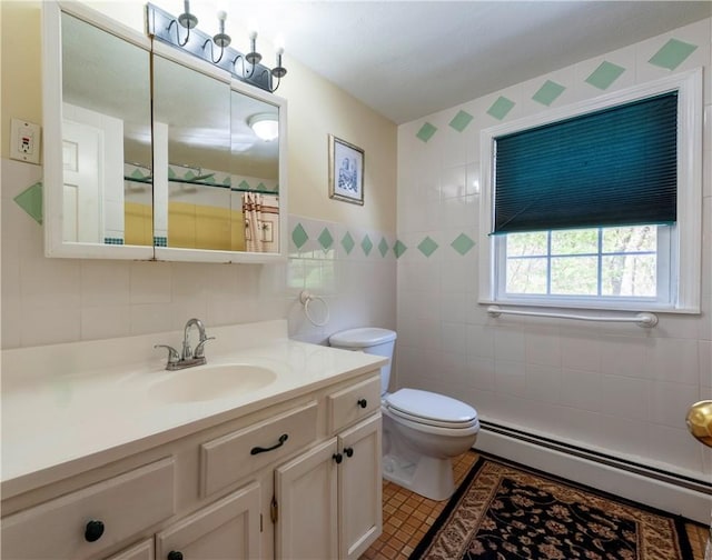 bathroom with tile walls, tile patterned floors, a baseboard radiator, vanity, and toilet