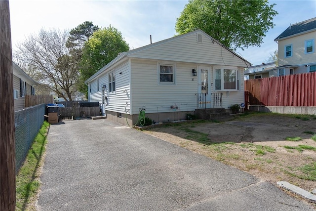 bungalow-style home with fence and driveway