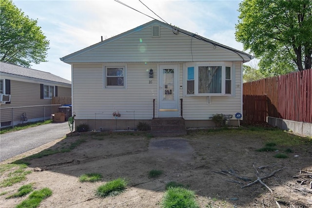 bungalow-style home featuring cooling unit, fence, and entry steps