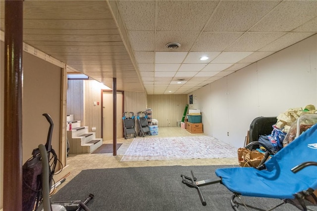 finished below grade area featuring recessed lighting, visible vents, a paneled ceiling, and stairway