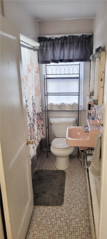 bathroom with toilet, tile patterned floors, a sink, and a shower with curtain