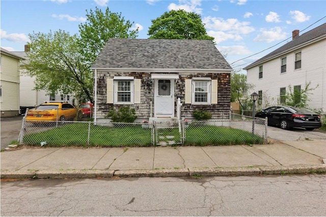 57 Clinton St, Pawtucket, RI 02861 - view of front of house featuring a gate, a fenced front yard, roof with shingles, and stone siding