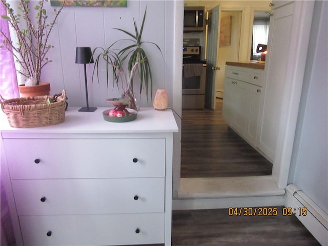 details with appliances with stainless steel finishes, wood finished floors, and baseboard heating