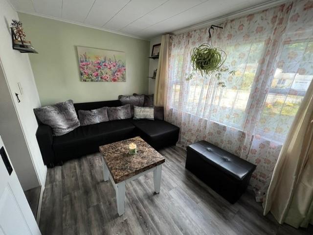 living room featuring crown molding and wood finished floors