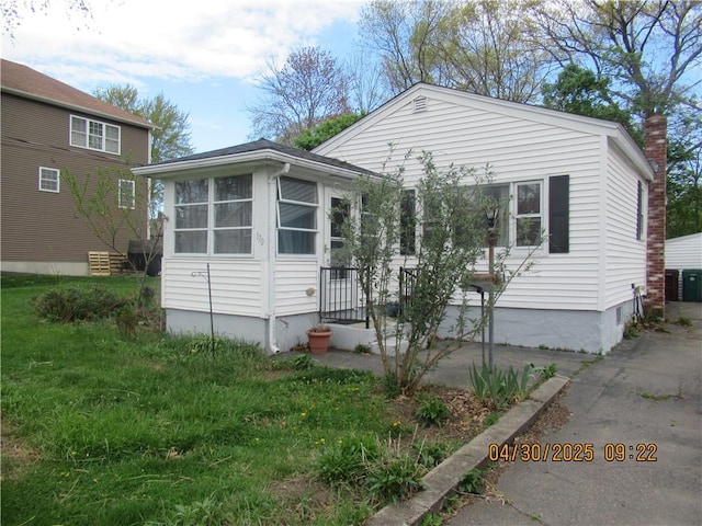 view of front of house featuring a chimney and a sunroom