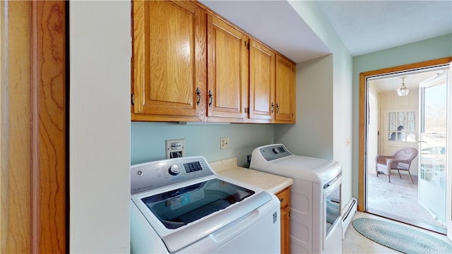 laundry room featuring separate washer and dryer, baseboard heating, and cabinet space