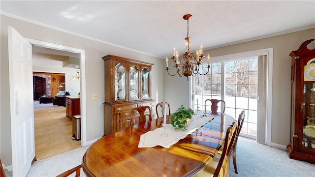 dining room with crown molding, a notable chandelier, and light colored carpet