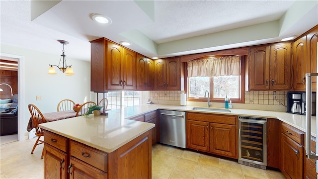 kitchen with tasteful backsplash, stainless steel dishwasher, a sink, a peninsula, and beverage cooler