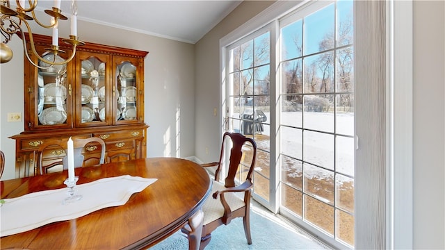 dining area with baseboards, crown molding, and a notable chandelier