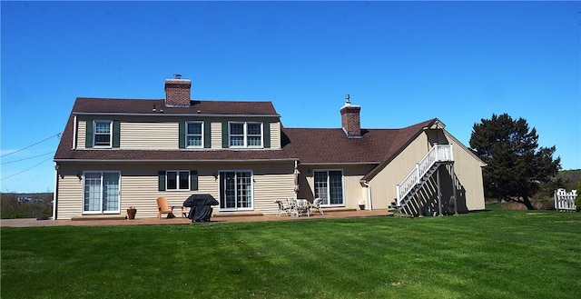 back of property featuring a lawn, a chimney, and a patio