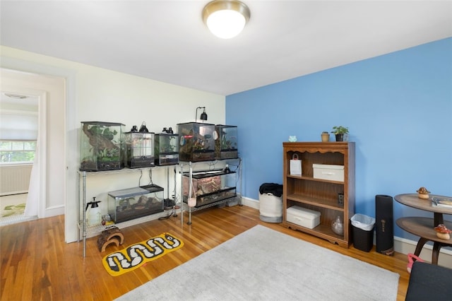 living area with baseboards and wood finished floors