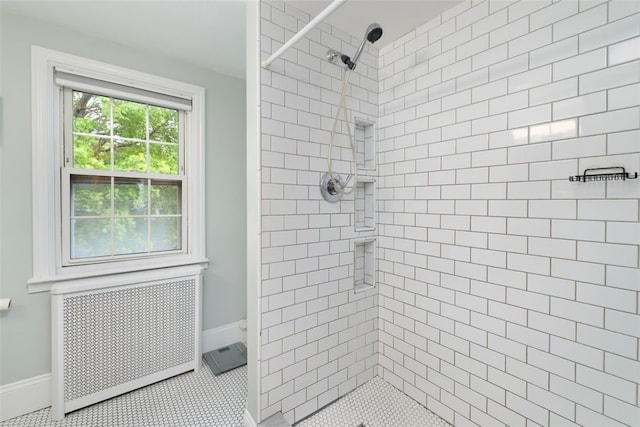 bathroom featuring radiator, baseboards, and a tile shower
