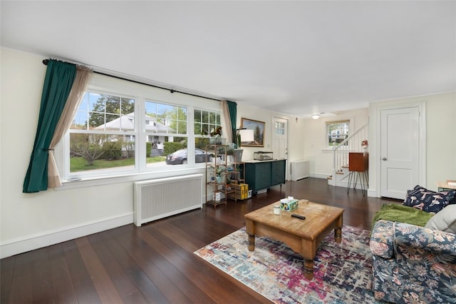 living room with stairs, baseboards, radiator heating unit, and wood finished floors