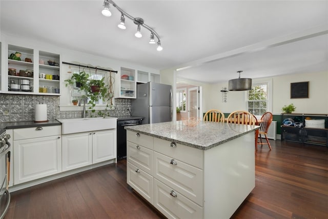 kitchen with open shelves, white cabinetry, tasteful backsplash, a sink, and appliances with stainless steel finishes