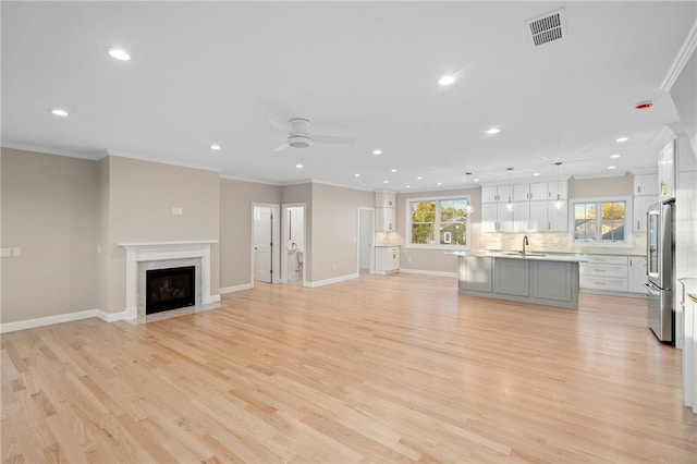 25 Scallop Shell Rd, Narragansett, RI 02882 - unfurnished living room featuring crown molding, recessed lighting, visible vents, and a sink