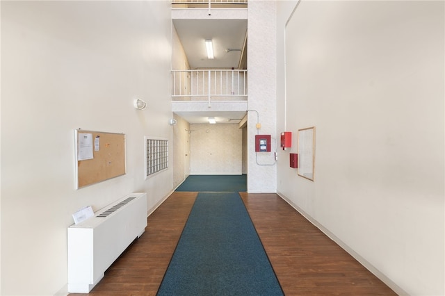 752 Quaker Ln Unit B108, Warwick, RI 02818 - hallway with radiator heating unit, wood finished floors, and a towering ceiling