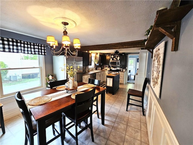 dining area with a textured ceiling, an inviting chandelier, and plenty of natural light