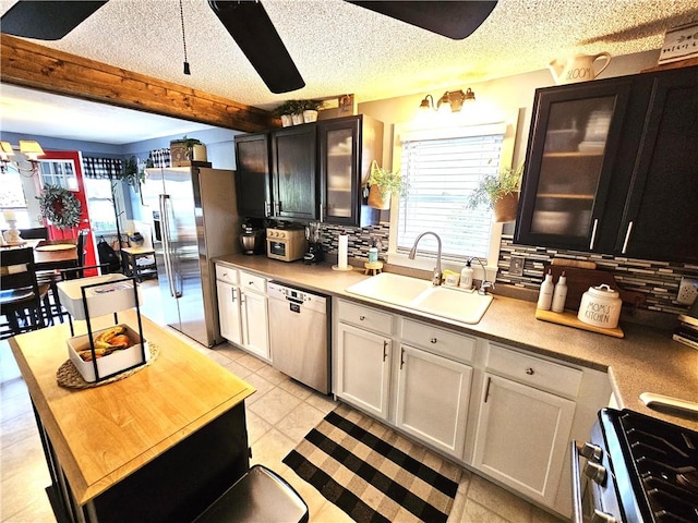 kitchen with a sink, tasteful backsplash, a ceiling fan, and stainless steel appliances