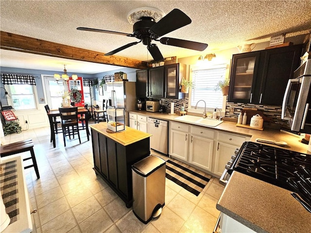 kitchen featuring a sink, plenty of natural light, a textured ceiling, and dishwasher