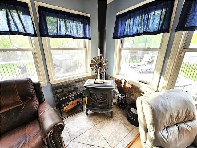 sitting room featuring tile patterned floors and a wood stove