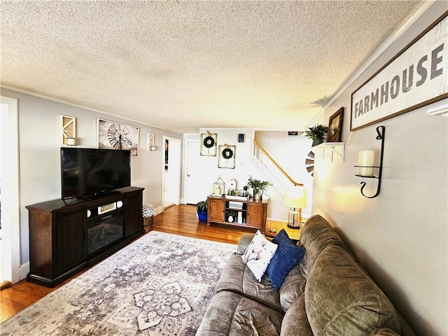 living room featuring stairs, a textured ceiling, and wood finished floors
