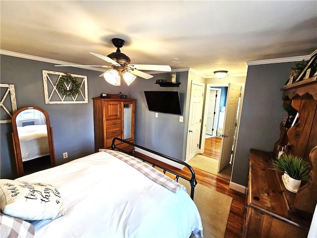 bedroom with crown molding, baseboards, a ceiling fan, and wood finished floors