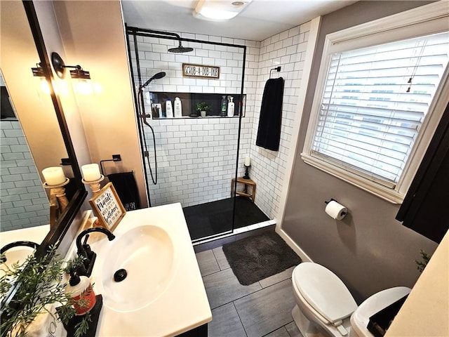 bathroom featuring vanity, baseboards, walk in shower, and toilet