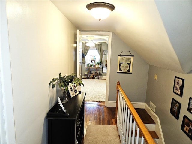 hall featuring an upstairs landing, wood finished floors, and vaulted ceiling
