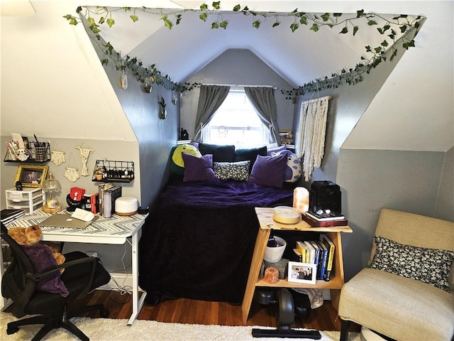 bedroom with wood finished floors and lofted ceiling