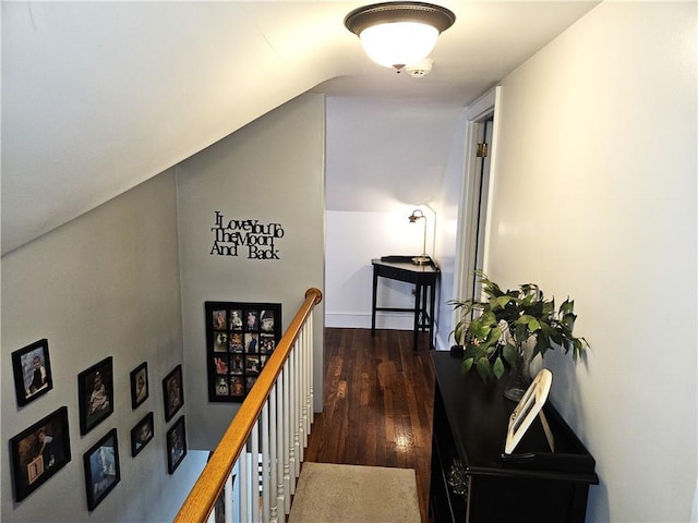 hall featuring vaulted ceiling, hardwood / wood-style flooring, and an upstairs landing