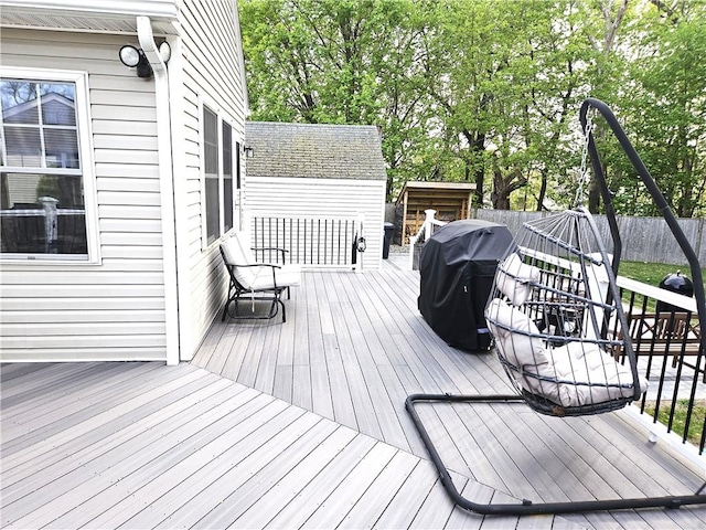 wooden deck with fence and area for grilling