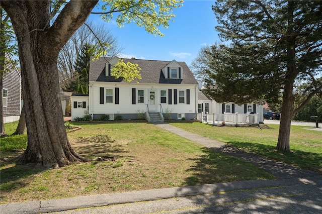 cape cod-style house featuring entry steps and a front yard