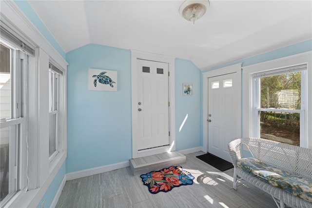 entryway featuring baseboards, wood finished floors, and lofted ceiling