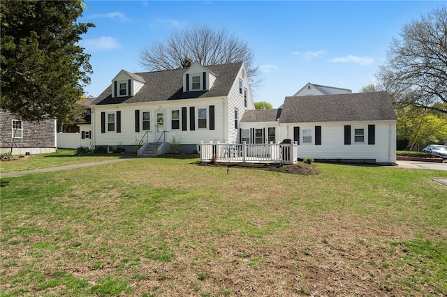 new england style home with a wooden deck and a front yard