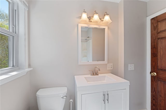 bathroom with vanity, a healthy amount of sunlight, and toilet
