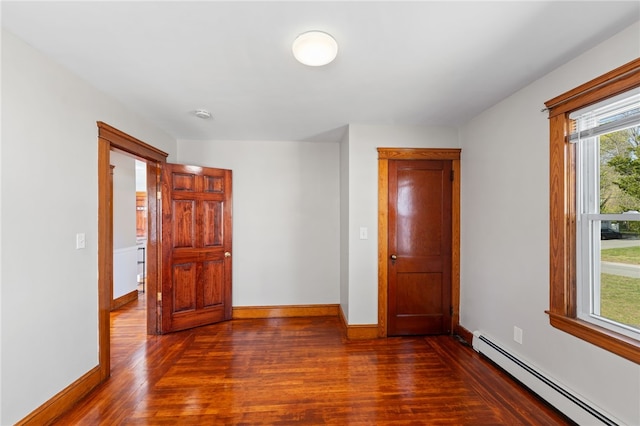 spare room featuring baseboards, dark wood-style floors, and baseboard heating
