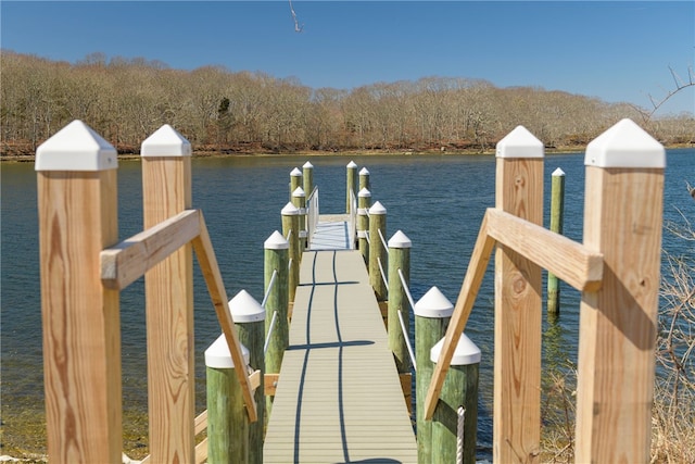 dock area with a water view and a wooded view