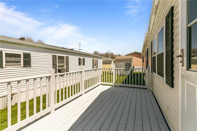 wooden terrace featuring an outdoor structure and a shed