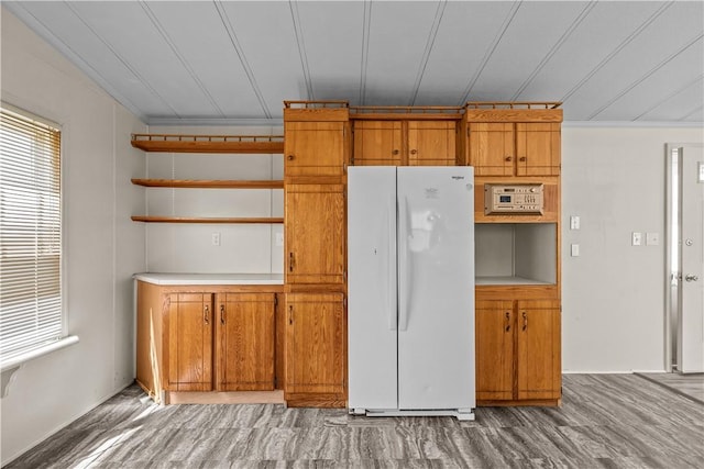 kitchen with open shelves, light countertops, freestanding refrigerator, and brown cabinets