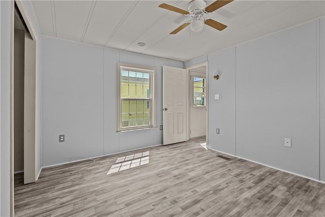 unfurnished room featuring a ceiling fan, wood finished floors, and visible vents