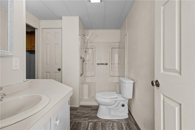 full bath featuring vanity, walk in shower, wood finished floors, and toilet