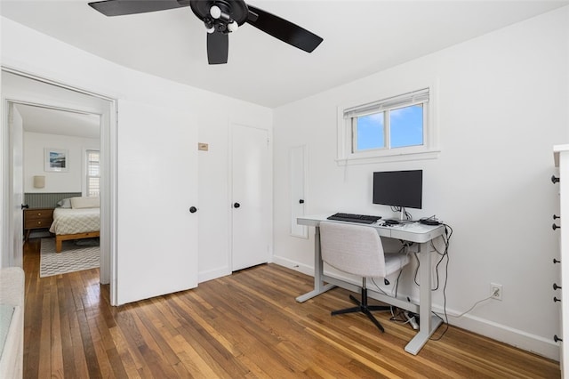 office area featuring wood-type flooring, baseboards, and ceiling fan