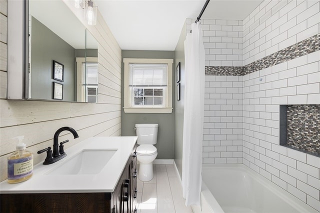 full bath featuring vanity, shower / bath combo with shower curtain, toilet, baseboards, and tile patterned floors